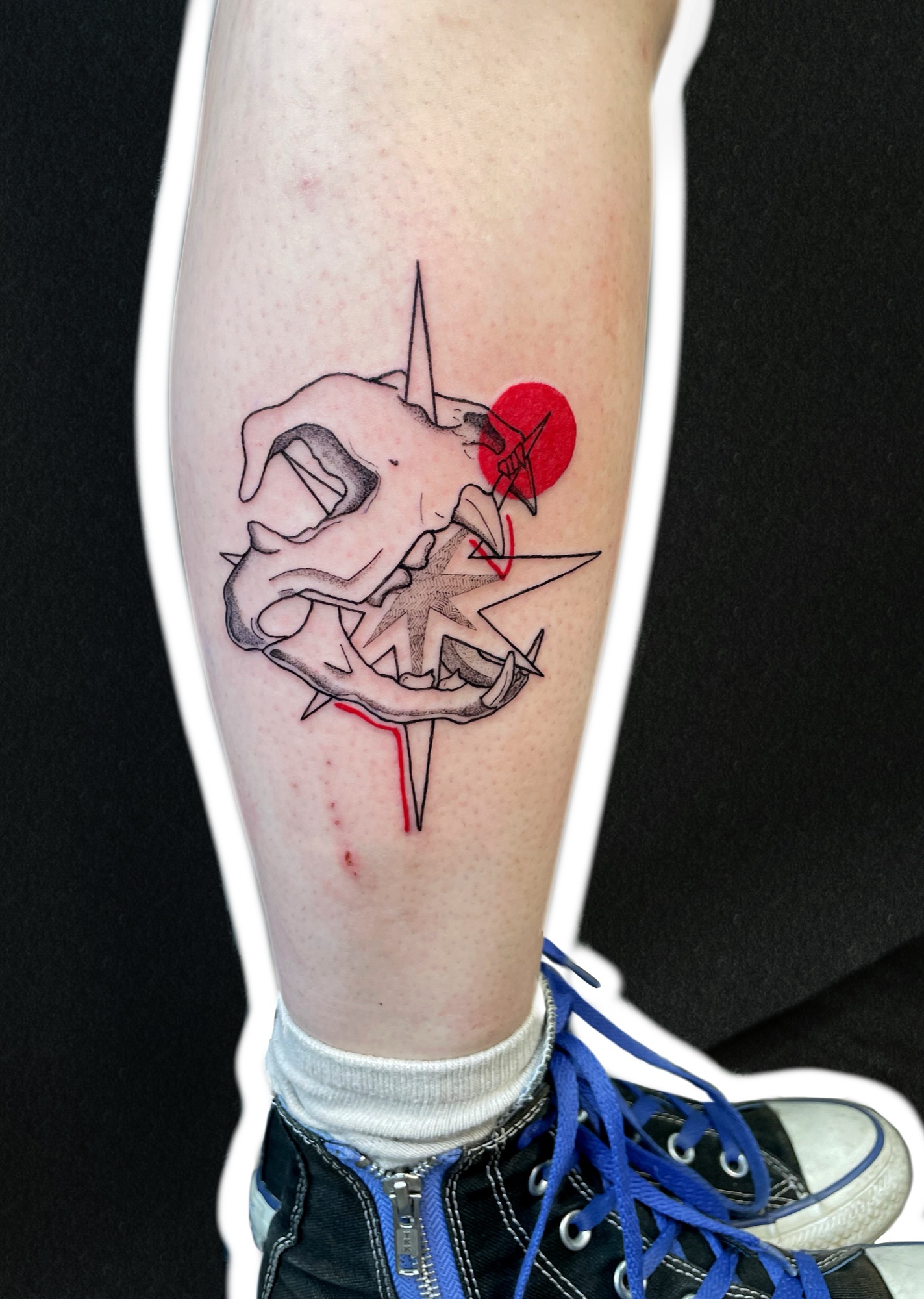 Skull with a compass star, calf tattoo