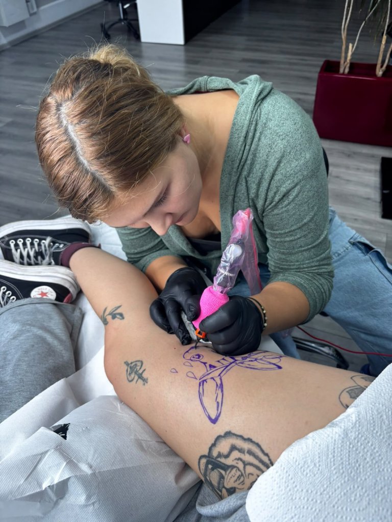 Alexandra S. tattooing a thigh in the studio